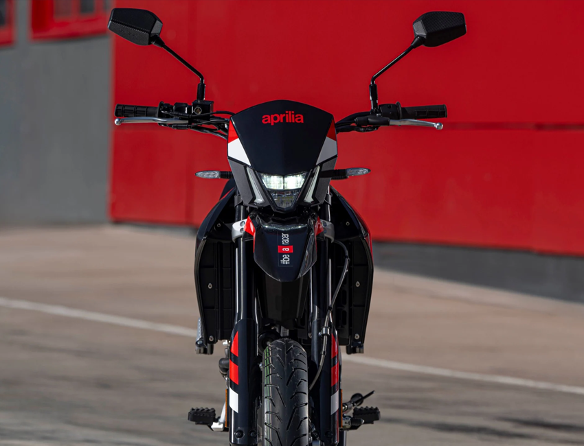 Aprilia SX 125 de face, phare allumé
