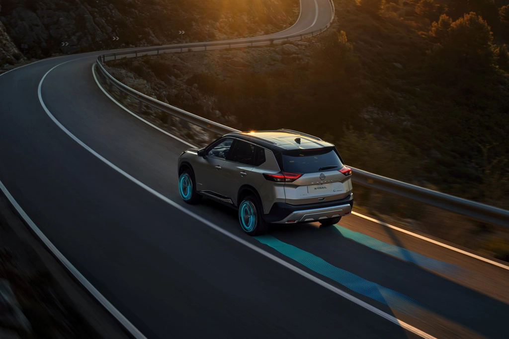 Nissan X-Trail Hybride rechargeable sur route de campagne, vue arrière